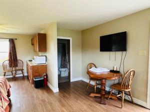 a room with a table and a television on the wall at Scenic Motel Moncton in Moncton