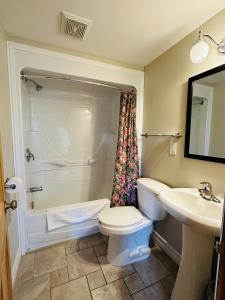 La salle de bains est pourvue de toilettes et d'un lavabo. dans l'établissement Scenic Motel Moncton, à Moncton