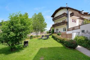 a large white building with a yard with benches at Residence zum Roessl 100 in Anterivo