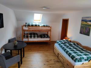 a bedroom with two bunk beds and a table at Richie's Landhaus im Allgäu in Pfaffenhausen