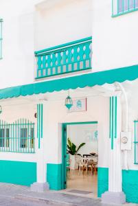 een blauw-wit gebouw met een tafel en stoelen bij Hotel Casa Turquesa in Flores