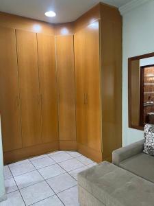 クイアバにあるCasa 3 suítes no centro de Cuiabáのリビングルーム(木製キャビネット、ソファ付)