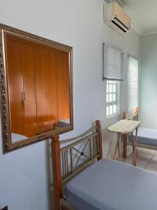 1 dormitorio con espejo, cama y mesa en Casa 3 suítes no centro de Cuiabá, en Cuiabá