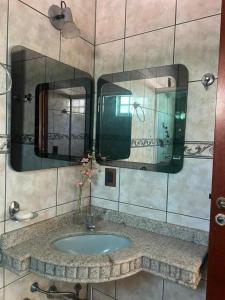baño con lavabo y 2 espejos en Casa 3 suítes no centro de Cuiabá, en Cuiabá