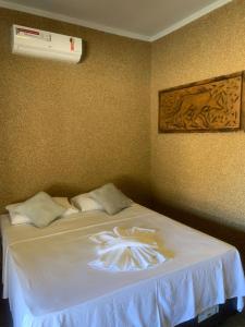 1 dormitorio con 1 cama con manta blanca en pousada solar da canastra en Delfinópolis