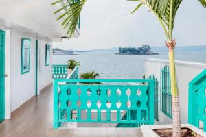 una casa con una barandilla azul y una palmera en Hotel Casa Turquesa, en Flores