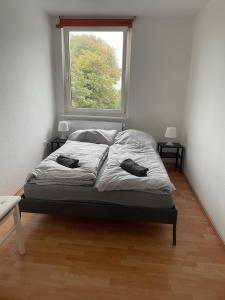Bett in einem Zimmer mit Fenster in der Unterkunft Schönes einfaches Zimmer zentral in Wilhelmshaven in Wilhelmshaven