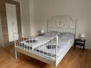 ein weißes Bett in einem Zimmer mit zwei Lampen in der Unterkunft Schönes einfaches Zimmer zentral in Wilhelmshaven in Wilhelmshaven