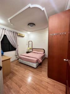 1 dormitorio con 1 cama y suelo de madera en Bintulu AirBnB Homestay en Bintulu