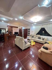 a living room with couches and tables and a room with at Bintulu AirBnB Homestay in Bintulu