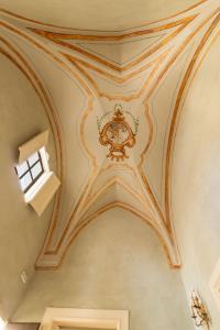 an ornate ceiling in a building with a window at Palazzo Zacà in Gallipoli