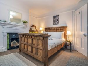 1 dormitorio con cama de madera y chimenea en Pass the Keys Spacious Home Rooftop Terrace Cafes Bars en Belfast