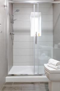 een douche met een glazen deur in de badkamer bij Modern Apartments Near Cardiff City Centre in Cardiff