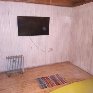 Habitación con TV de pantalla plana en la pared en CASA kuntur en Cajon del Maipo