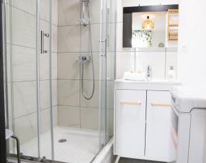 Un baño blanco con ducha y lavabo. en Spacieux et douillet T2 au centre, en Valence