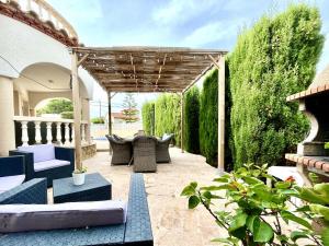 une terrasse avec des chaises et une pergola en bois. dans l'établissement Villa Avondale 3bedroom villa with air-conditioning & private swimming pool, à L'Ametlla de Mar