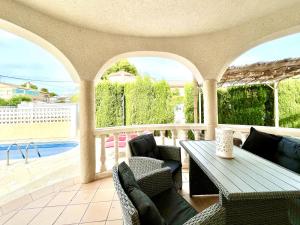 ラメトリャ・デ・マールにあるVilla Avondale 3bedroom villa with air-conditioning & private swimming poolのパティオ(テーブル、椅子付)、プールが備わります。