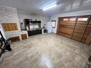 a large empty room with a kitchen and a refrigerator at Casa mais Central de Gramado in Gramado