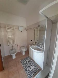 ein Badezimmer mit einem Waschbecken, einem WC und einem Spiegel in der Unterkunft CAMERA PRIVATA IN VILLA CON INGRESSO INDIPENDENTE,ingresso dal bagno in Ponte San Giovanni