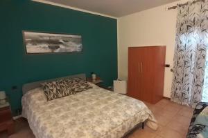 a bedroom with a bed and a green wall at CAMERA PRIVATA IN VILLA CON INGRESSO INDIPENDENTE,ingresso dal bagno in Ponte San Giovanni