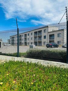 a building with a fence in front of it at Delightful Retreat in Parklands,Cape Farms,Cape Town in Cape Town