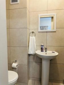 a bathroom with a sink and a toilet at Delightful Retreat in Parklands,Cape Farms,Cape Town in Cape Town