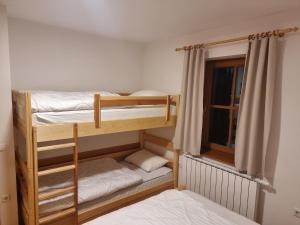 two bunk beds in a room with a window at Bolfenk Snowflake app in Hočko Pohorje