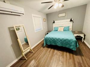Schlafzimmer mit einem Bett und einem Spiegel in der Unterkunft Casita Blanca- Close To Downtown in Waco