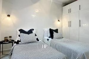 twee bedden in een kamer met witte muren bij Offer -20 I Dream Apartment in Marrakech in Marrakesh