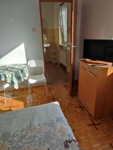 にあるAgroturystyka LUCYNAのベッド、テレビ、テーブルが備わる客室です。