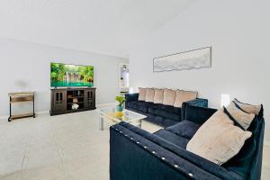 ein Wohnzimmer mit einem Sofa und einem TV in der Unterkunft Stunning Family Retreat with Pool, Hot Tub, Patio, King Bed in Kissimmee