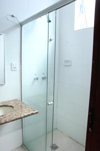 a glass shower with a sink in a bathroom at Hotel Metropolitano in Coronel Fabriciano