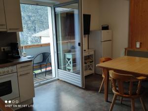 cocina con mesa y puerta corredera de cristal en groassehof Haus Gstrein en Imsterberg