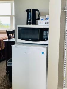 a microwave sitting on top of a refrigerator at Scenic Motel Moncton in Moncton