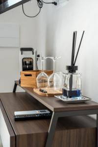 un tavolo con bicchieri e una macchinetta del caffè. di Murieri Rooms a Otranto