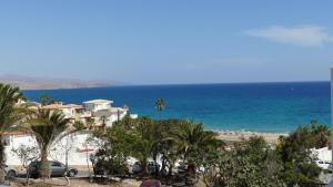 a view of a beach with palm trees and houses at Blue Lagoon Apartment in Costa Calma