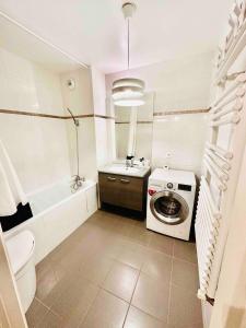 a bathroom with a washing machine and a sink at Parc des Expositions Appartement 4 personnes Parking Gratuit in Villepinte