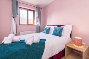 una camera da letto con un letto con lenzuola bianche e cuscini blu di Derby Wilson Ave - Spacious 2 Bedroom Apartment with Garden a Derby