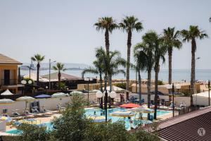 a view of a resort with palm trees and a swimming pool at Andrea Case Vacanze L'Ancora in Porto Empedocle