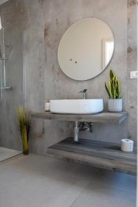La salle de bains est pourvue d'un lavabo et d'un miroir. dans l'établissement Murieri Rooms, à Otrante