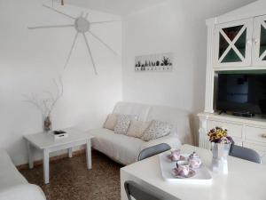 a living room with a white couch and a tv at Casa Rosella - Formentera Break in San Ferrán de ses Roques