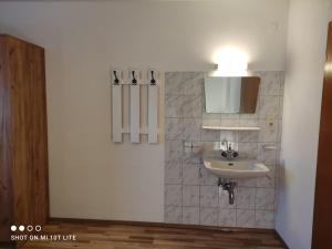 een badkamer met een wastafel en een lampje aan de muur bij groassehof Haus Gstrein in Imsterberg