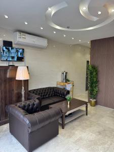 uma sala de estar com um sofá de couro e uma mesa em فندق بانسي em Abha