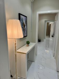um quarto com um candeeiro e um corredor branco em فندق بانسي em Abha