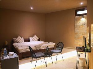 1 dormitorio con 1 cama, mesa y sillas en Alaqur View Inn نزل واجهة العقر en Nizwa