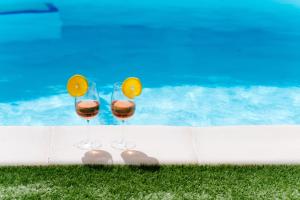 dos copas de vino sentadas junto a una piscina en La Dolce Vita El Salobre, en Salobre