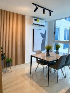 - une salle à manger avec une table et des chaises dans l'établissement Apartamento con piscina infinita frente al mar en Avenida Balboa PH The Sand, à Panama City