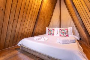 Cama en habitación con paredes de madera en Hostel Da Vila Ilhabela, en Ilhabela