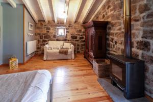 uma sala de estar com um fogão a lenha numa parede de pedra em Cabaña Pasiega Las Suertes em San Pedro del Romeral