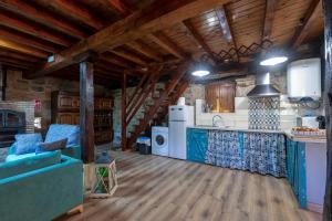 una cocina con suelo de madera y una cocina con armarios azules en Cabaña Pasiega Las Suertes en San Pedro del Romeral